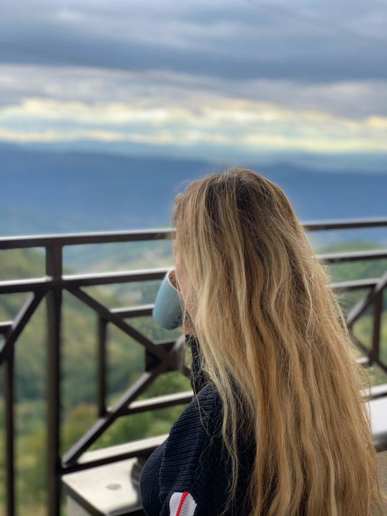 one person, long hair, blond hair, hairstyle, women, railing, rear view, sky, adult, cloud, leisure activity, blue, nature, lifestyles, day, young adult, water, sea, person, travel, headshot, portrait, looking, outdoors, looking at view, focus on foreground, transportation, casual clothing, human hair, female, vacation, architecture, trip, holiday, clothing, child, standing, brown hair, contemplation