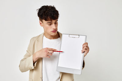 Man showing clipboard against gray background