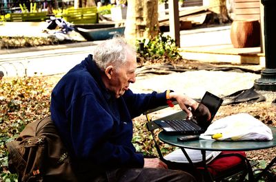 Man holding food while sitting outdoors