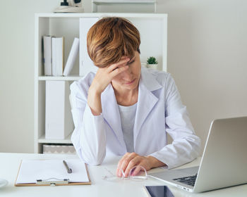 Female medicine worker touching forehead. tiredness and sickness. negative aspect of hardworking