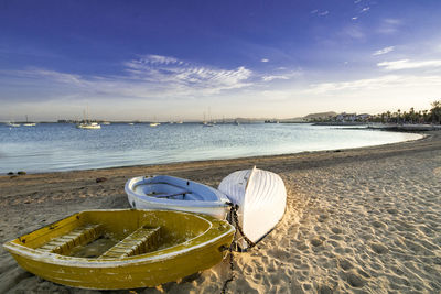 Boat moored on beach against sky