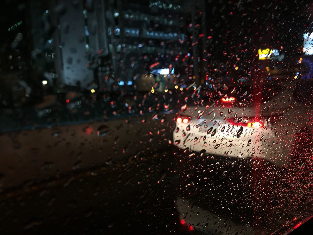 VIEW OF CITY STREET SEEN THROUGH WET WINDOW