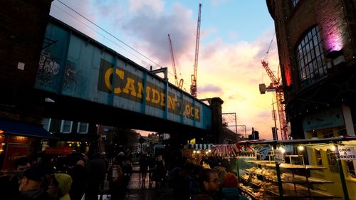 People at market in city against sky