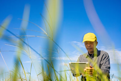 Man working against blue sky