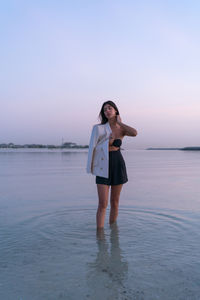 Portrait of a beautiful middle eastern woman standing in the water wearing a jacket