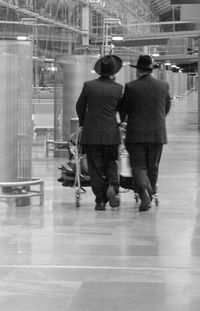 Rear view of people walking in corridor