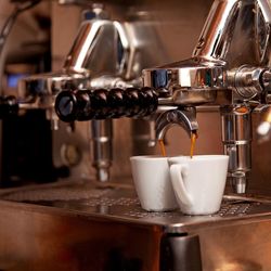 Italian expresso machine on a counter in a restaurant or bar making two coffee