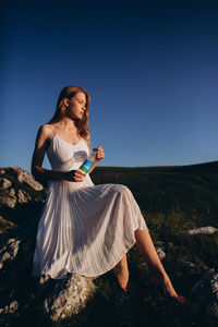 Woman on field against clear blue sky