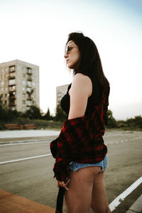 Side view of woman standing against sky