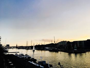 Sailboats in city at sunset