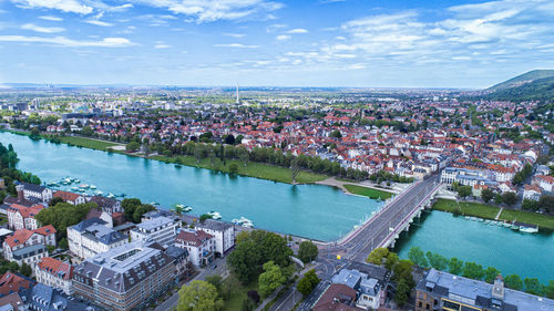 High angle view of river amidst buildings in town against sky