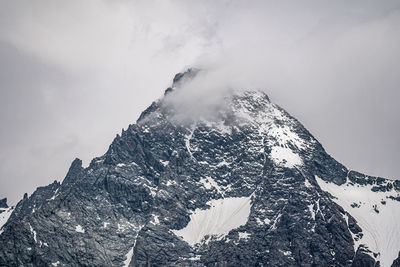 Low angle view of snowcapped mountain against sky