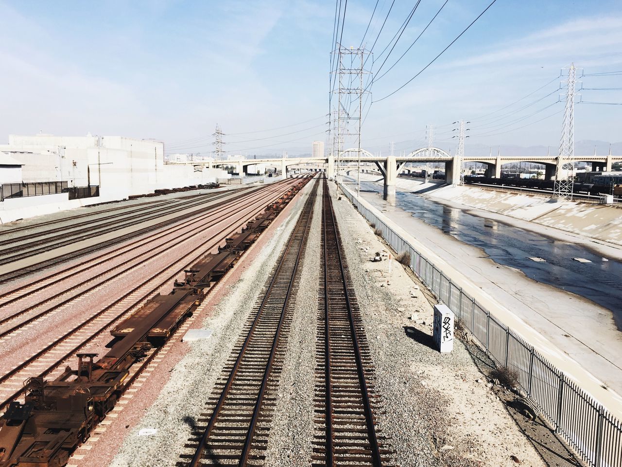 railroad track, rail transportation, the way forward, transportation, diminishing perspective, vanishing point, sky, built structure, power line, public transportation, architecture, connection, railroad station, railroad station platform, electricity pylon, railway track, cloud - sky, power supply, cable, day