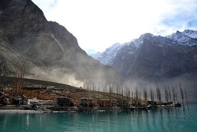 Scenic view of lake by mountains against sky