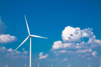 Low angle view of windmill against blue sky