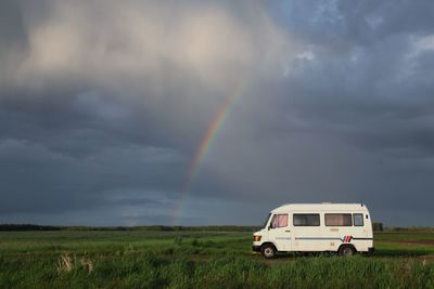 Scenic view of rainbow over field against sky