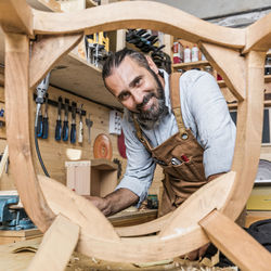 Portrait of carpenter working on wood in workshop