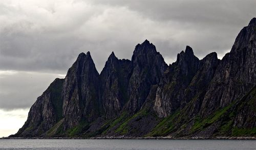 Panoramic view of cliff by sea against sky