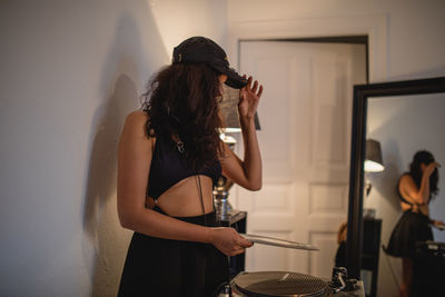 Fashionable young woman playing music at home