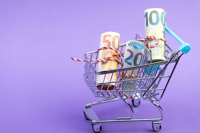 Close-up of toy shopping cart against blue background