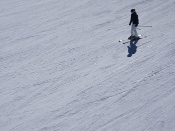 Side view of person skiing on snow covered field