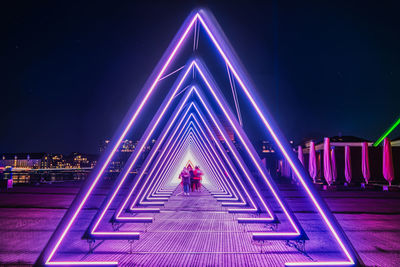 Illuminated bridge against sky in city at night