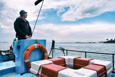 Full length of man fishing in sea against sky