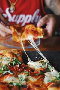 Midsection of man having pizza on table