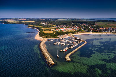 High angle view of city by sea against sky