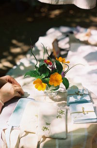 Cropped image of hands by vase on table