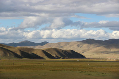 Scenic view of field against cloudy sky