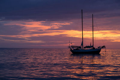 Sailboat in sea at sunset