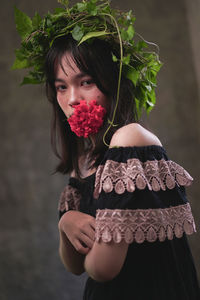 Portrait of woman holding red flower