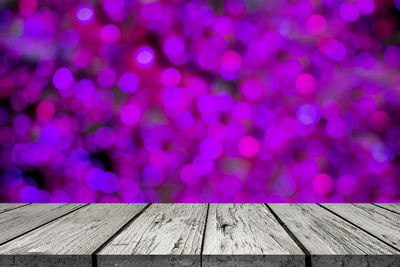 Defocused image of illuminated lights on wooden table