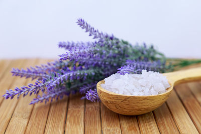 Close-up of bath salt and purple flowers on table