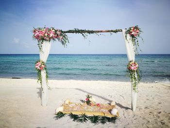 Flower vase on table against sea