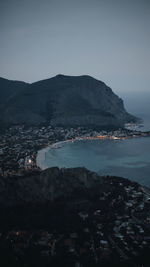 Aerial view of city by sea against clear sky