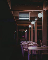 Empty chairs and tables in illuminated building