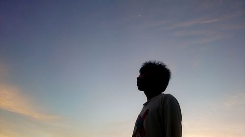 Low angle portrait of silhouette man standing against sky during sunset