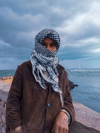 Portrait of man standing by sea against sky