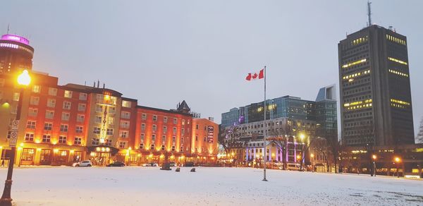 Illuminated buildings against sky during winter