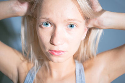 Close-up portrait of young woman against wall