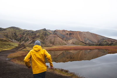 Rear view of man standing against mountain