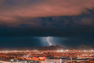 Illuminated cityscape against sky at night