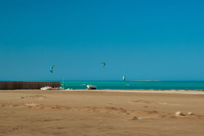 Scenic view of beach against clear blue sky