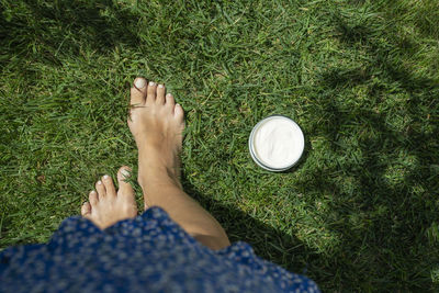 Low section of woman with pills on field