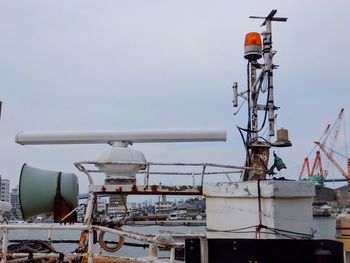 Low angle view of telephone pole by sea against sky