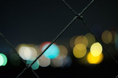 Defocused image of illuminated city against clear sky at night