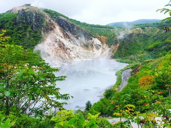 Scenic view of waterfall against sky