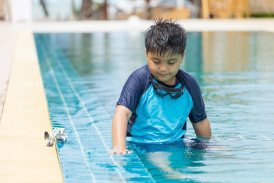 Portrait of boy swimming in pool